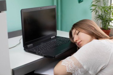 Öğrenci evde çalışmaktan yorulurken dizüstü bilgisayarda uyuyakaldı..