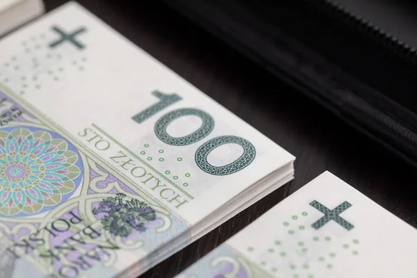 Polish paper currency is valid throughout the country and is the basic and official means of payment. Polish paper banknotes with a face value of PLN 100 are the official currency of the country and are on the table.