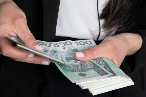 女性は100枚の紙幣を正確に計算している ポーランドのデノミネーションに銀行券の厚いスタックをカウントするときにクローズアップショット — ストック写真