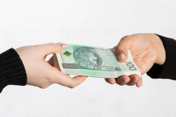 ズームでは 女性の手が現金を交換しているのを見ることができます 2人の若い女性の手はポーランドの銀行券の束を与え 一方はそれらを上から保護します — ストック写真