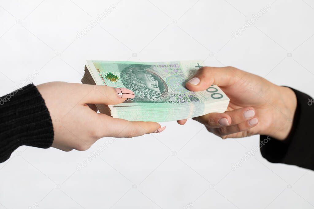 On the zoom you can see female hands full of banknotes as they exchange cash. The businesswoman hands a bundle of banknotes as an additional bonus to the salary.