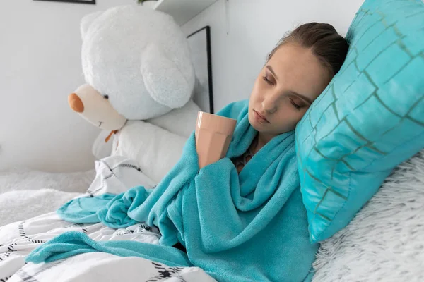 The young girl drinks a special hot infusion of herbs to return to full health faster.