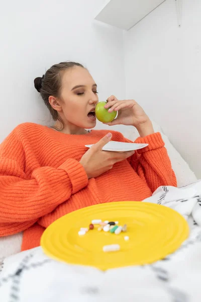 Uma Adolescente Senta Sua Cama Sob Cobertas Com Uma Camisola — Fotografia de Stock