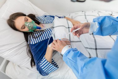 Doktor venflonu genç bir kızın eline takmanın doğruluğunu kontrol ediyor..