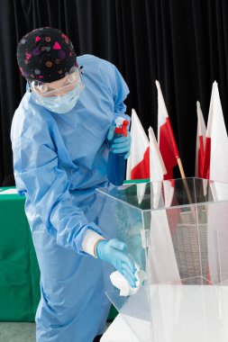 Çalışan özel bir takım elbise giyiyor. Tüm yüzeylerde dezenfeksiyon. Cumhurbaşkanlığı seçimi.