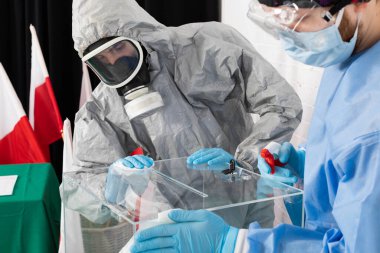 Polonya 'daki başkanlık seçiminden hemen önce oy sandığının iki kişi tarafından iyice kontrol edilmesi, temizlenmesi ve dezenfekte edilmesi.