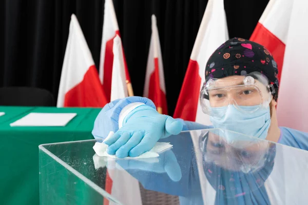 El empleado durante la desinfección trata de limpiar completamente cada pulgada de las urnas para evitar la infección . — Foto de Stock