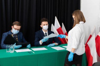 Genç bir adam ve genç adam bir masada oturmuş seçmenleri bekliyorlar..