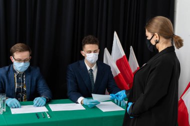 Oy sandığı. İçinde oy pusulası olan bir zarf. Tamamlanmış oy pusulasını bir zarfın içinde sandığa atıyor..