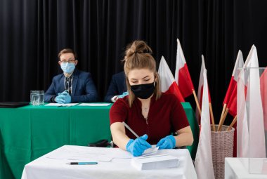 Yetişkin bir genç, sandık merkezinde tekerlekli sandalyede. Tekerlekli sandalye için bariyer yok.