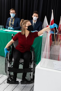 Oy sandığına atmakta zorlanıyorum. Tekerlekli sandalyedeki bir genç. Polonya cumhurbaşkanına oy verin.