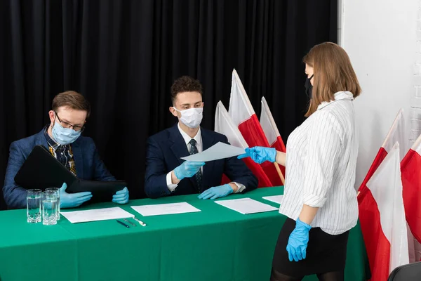 Genç bir adam ve genç adam bir masada oturmuş seçmenleri bekliyorlar..