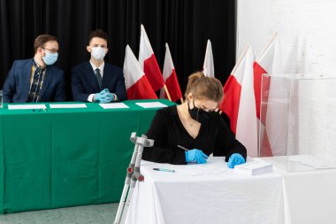 Ortopedik top. Oy verme zorunluluğu. Lublin 'deki oy kullanma merkezi. Genç bir yetişkin seçim kartı dolduruyor..