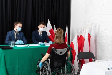 Tekerlekli sandalyedeki bir kadın. Polonya 'da başkanlık seçimleri. Sandık merkezi sakatlar için uyarlandı.