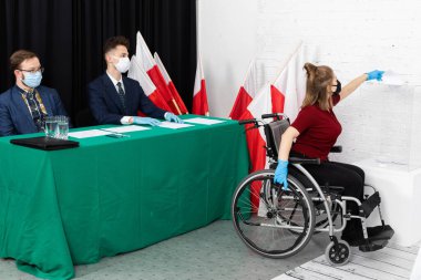 Oy sandığına atmakta zorlanıyorum. Tekerlekli sandalyedeki bir genç. Polonya cumhurbaşkanına oy verin.