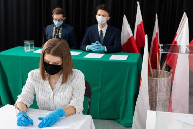 Yeşil bezle kaplı bir masa. Seçim komisyonu masada oturuyor. Polonya 'da cumhurbaşkanlığı seçimleri.