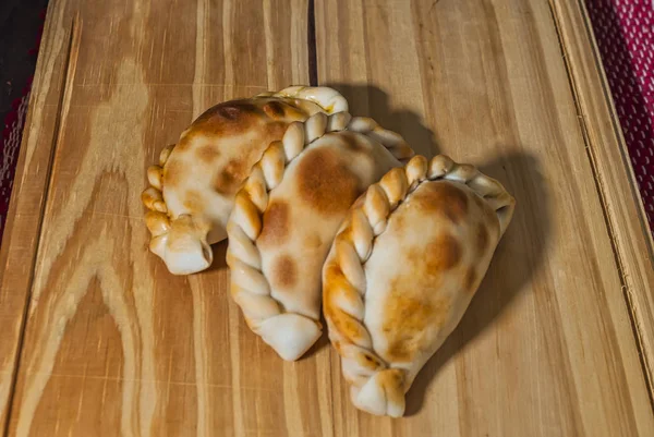 Mesa de madeira com Empanadas caseiras frescas (close-up detalhado; foco seletivo ) — Fotografia de Stock