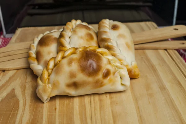 Mesa de madeira com Empanadas caseiras frescas (close-up detalhado; foco seletivo ) — Fotografia de Stock