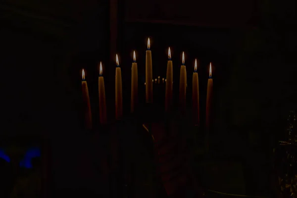 Menorah com velas acesas em celebração de Chanukah. Uma vela simbólica acendendo para o feriado judaico de Hanukkah. A oitava e última noite de Hanukkah . Fotos De Bancos De Imagens