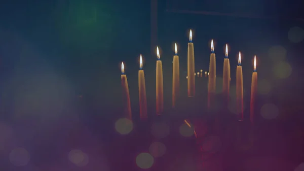 Menorah com velas acesas em celebração de Chanukah. Uma vela simbólica acendendo para o feriado judaico de Hanukkah. A oitava e última noite de Hanukkah . Imagens De Bancos De Imagens