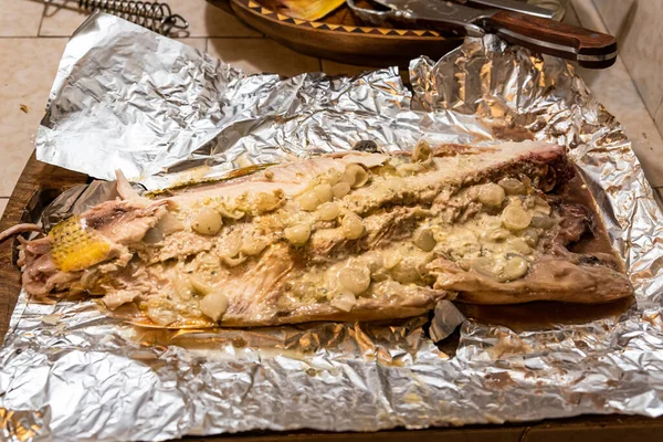 Peixe dorado grelhado caseiro com legumes embrulhados em folha de alumínio na mesa rústica. Vista superior . — Fotografia de Stock