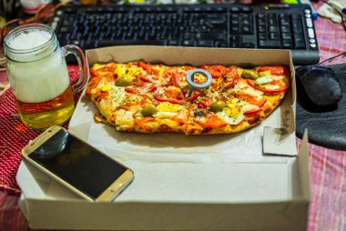 Evde çalış ve yemek götür. Sağlıksız yaşam tarzı olan bir ev. Laptop ve fast food ile vakit geçirmek. Fast food pizza ve bilgisayar masada. Üst Manzara. seçici odak.