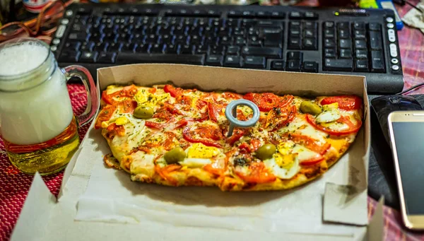 Work at home and deliver food. Home with unhealthy lifestyle. Leisure with laptop and fast food. fast food pizza and computer on the table. Top view. selective focus.