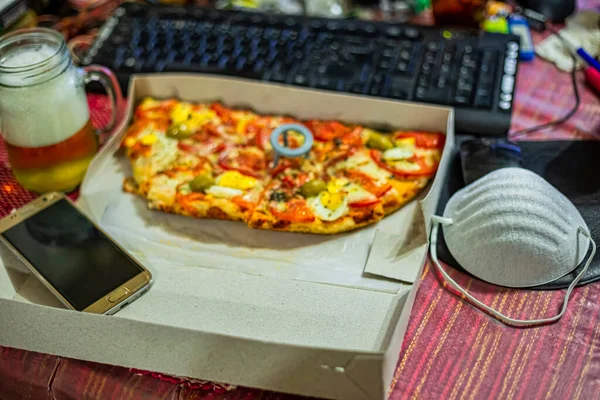 Work at home and deliver food. Home with unhealthy lifestyle. Leisure with laptop and fast food. fast food pizza and computer on the table. Top view. selective focus.