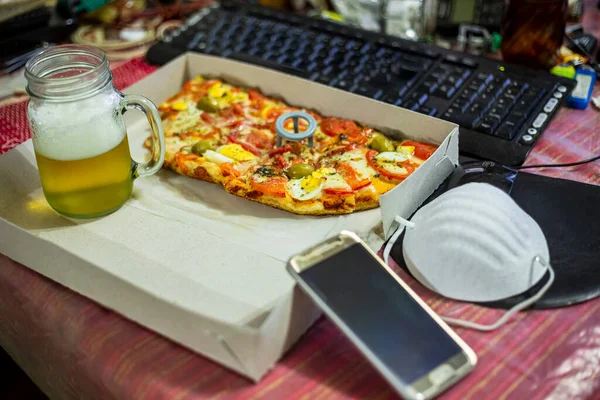 Work at home and deliver food. Home with unhealthy lifestyle. Leisure with laptop and fast food. fast food pizza and computer on the table. Top view. selective focus.