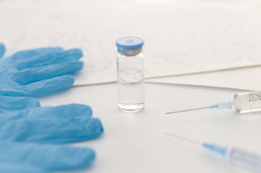 İlaç şişesi, mavi lastik eldivenler, şırıngalar, arka planda el yazısıyla yazılmış formüller. Coronavirus aşısı geliştirme. 2019 nCoV sıvı ilaç, virüs panzehiri. Uzayı kopyala Sağlık kavramı