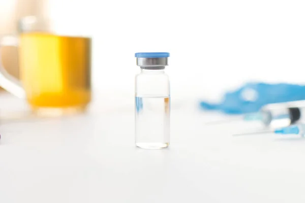 医学ボトル 青ゴム手袋 注射器と光の背景に緑茶のカップ コロナウイルスワクチン開発 医療機器 2019 Ncov液体薬 ウイルス解毒剤 ヘルスケアの概念 — ストック写真