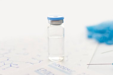 İlaç şişesi, mavi lastik eldivenler, şırıngalar, el yazısıyla yazılmış formüller ve arka planda pandemik yazılar. Coronavirus aşısı geliştirme. 2019 nCoV sıvı panzehiri. Boşluğu kopyala