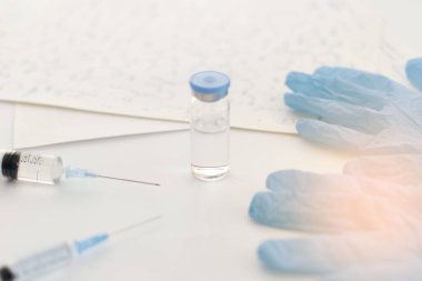 İlaç şişesi, mavi lastik eldivenler, şırıngalar, arka planda el yazısıyla yazılmış formüller. Coronavirus aşısı geliştirme. 2019 nCoV sıvı ilaç, virüs panzehiri. Uzayı kopyala Sağlık kavramı