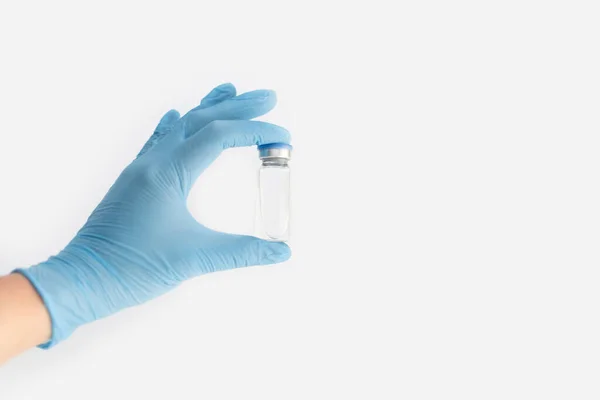 医師は 青いカバーと灰色の背景にクリア流体と青いゴム手袋薬瓶を保持手 コロナウイルスワクチン開発 2019 Ncv液体薬 ウイルス解毒剤 スペースのコピー — ストック写真