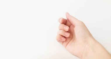 Yumuşak kare şeklinde tırnakları olan kadın eli parmaklarında bir şey tutuyor. Kadın sanal nesneyi saklar. Evde çivi bakımı. Boşluğu kopyala