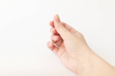 Yumuşak kare şeklinde tırnakları olan kadın eli parmaklarında bir şey tutuyor. Kadın sanal nesneyi saklar. Evde çivi bakımı. Boşluğu kopyala