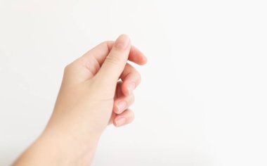 Yumuşak kare şeklinde tırnakları olan kadın eli parmaklarında bir şey tutuyor. Kadın sanal nesneyi saklar. Evde çivi bakımı. Boşluğu kopyala