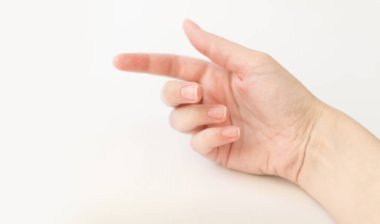 Yumuşak kare şeklinde tırnakları olan kadın eli parmaklarında bir şey tutuyor. Kadın sanal nesneyi saklar. Evde çivi bakımı. Boşluğu kopyala