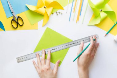 Evde çocuklarla kağıt yeşili yel değirmeni oyuncağı yapmayı. Adım adım talimatlar. Eller DIY yaz projesi yapıyor. Üst Manzara. Üçüncü adım. Karenin diğer köşelerini doğruya bağla