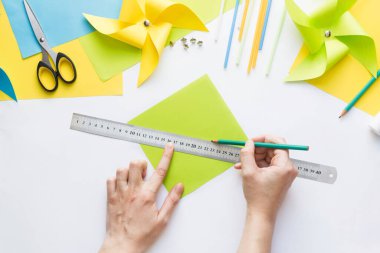 Evde çocuklarla kağıt yeşili yel değirmeni oyuncağı yapmayı. Adım adım talimatlar. Eller DIY yaz projesi yapıyor. Üst Manzara. Adım 2. Karenin zıt köşeleri arasında çizgi çiz