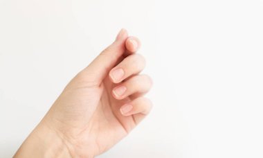 Yumuşak kare şeklinde tırnakları olan kadın eli parmaklarında bir şey tutuyor. Kadın sanal nesneyi saklar. Evde çivi bakımı. Boşluğu kopyala