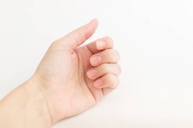 Yumuşak kare şeklinde tırnakları olan kadın eli parmaklarında bir şey tutuyor. Kadın sanal nesneyi saklar. Evde çivi bakımı. Boşluğu kopyala