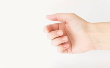 Yumuşak kare şeklinde tırnakları olan kadın eli parmaklarında bir şey tutuyor. Kadın sanal nesneyi saklar. Evde çivi bakımı. Boşluğu kopyala