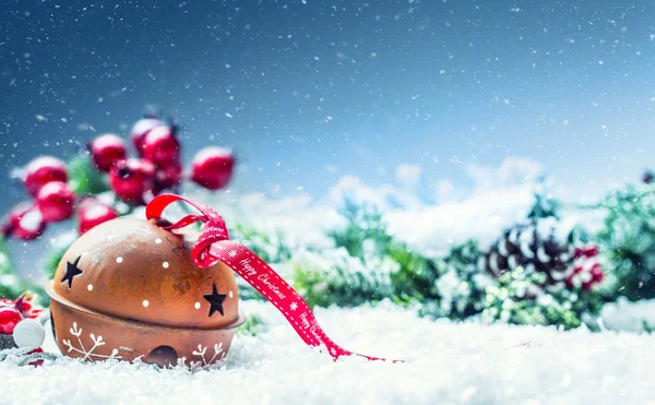 Vánoční koule rolničky. Červená stuha s textem Veselé Vánoce. Zasněžené abstraktní pozadí a dekorace — Stock fotografie