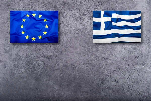 Banderas de la Unión Europea y Grecia sobre fondo concreto — Foto de Stock