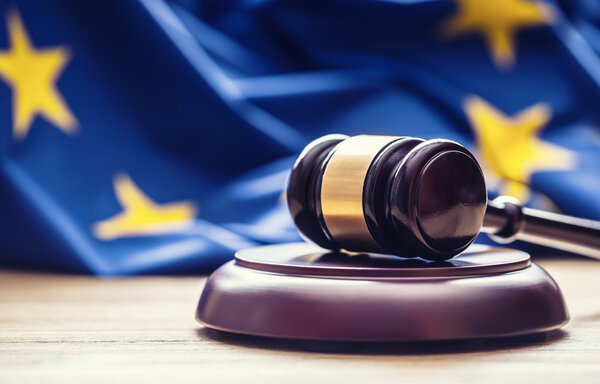 Judges wooden gavel with EU flag in the background. Symbol for jurisdiction