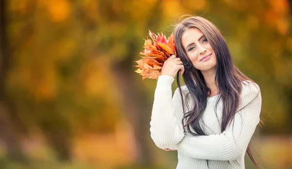 Young attractive woman with bouquet autumn leaves in hand. Fall. — Stock Photo, Image
