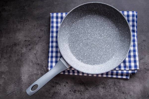 Ceramic pan on concrete kitchen board. Kitchen utensil. Empty pan