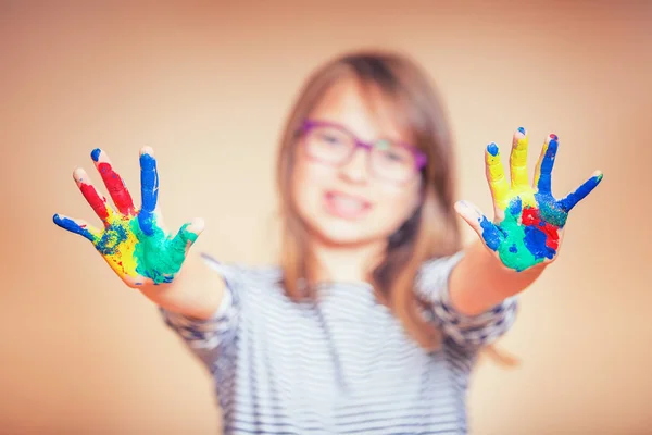 Retrato de uma menina estudante pré-adolescente mostrando as mãos pintadas. Foto tonificada — Fotografia de Stock