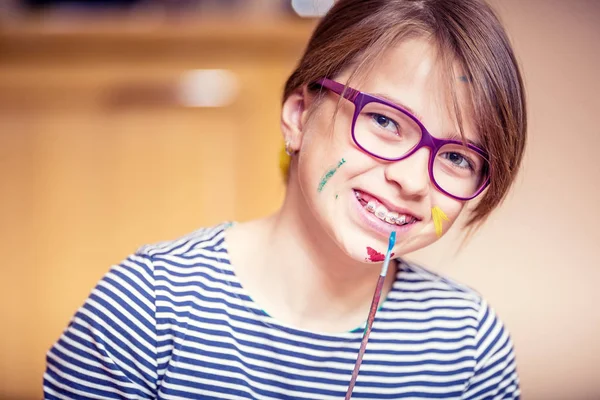 Retrato de uma pequena estudante pré-adolescente pintando em casa. Foto tonificada — Fotografia de Stock